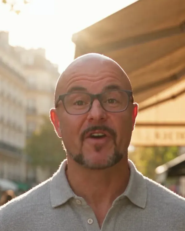 The same presenter outside a European street café